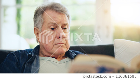 Face, senior and man for reading in living room with closeup on sofa for peaceful, calmness or relaxing. Elderly person, alone and retirement with book for thinking, information or knowledge in home 110361593
