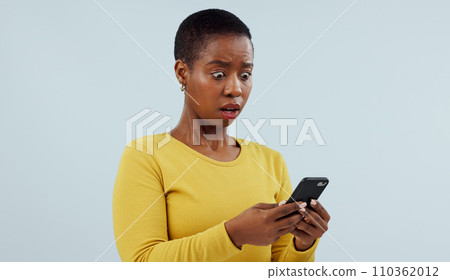 Black woman, phone and shocking news on social media, terrifying or online against a studio background. Face of surprised African female person or model on mobile smartphone for alert notification Black woman, phone and shocking news on social media, terrifying or online against a studio background. Face of surprised African female person or model on mobile smartphone for alert notification 110362012
