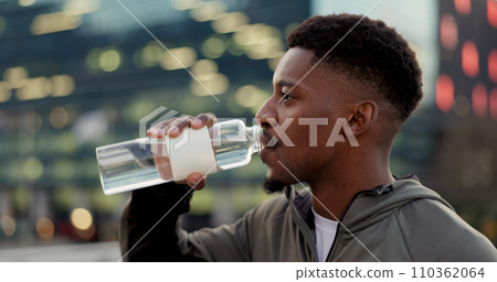 Black man, drinking water and fitness in city after workout, exercise or outdoor training for natural sustainability. Thirsty African male person with mineral drink on break for hydration in town 110362064