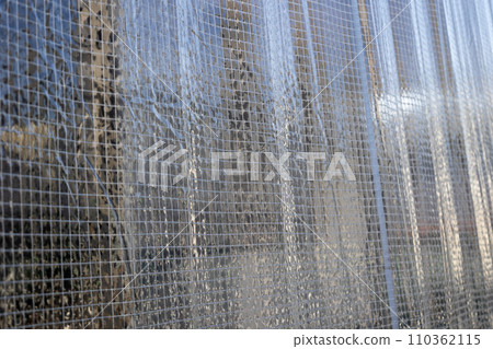 Close-up background of transparent vinyl curtain with flame retardant thread Close-up background of transparent vinyl curtain with flame retardant thread 110362115