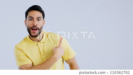 Man, portrait and pointing up in surprise on mockup for deal, advertising or marketing against a gray studio background. Shocked or surprised male person or model showing notification, alert or sale 110362702
