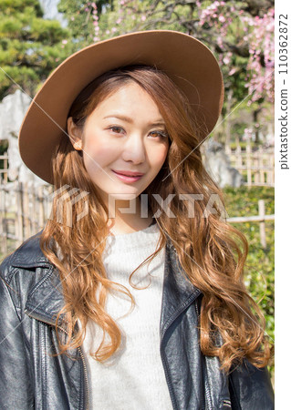 A woman with long hair wearing a weeping plum and a hat A woman with long hair wearing a weeping plum and a hat 110362872