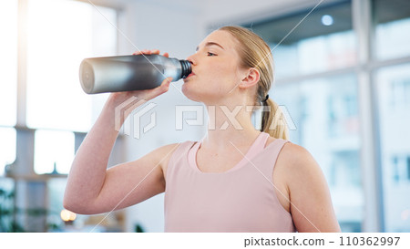Woman, home and drink of water for sports break, energy and workout performance. Thirsty athlete, bottle and nutrition of hydration, diet or healthy liquid for training, exercise or fitness in lounge 110362997