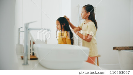 Family, bathroom and a girl brushing the hair of her sister in their home for morning routine or care. Kids, beauty or haircare with a young child and helping sibling in their apartment for love Family, bathroom and a girl brushing the hair of her sister in their home for morning routine or care. Kids, beauty or haircare with a young child and helping sibling in their apartment for love 110363067