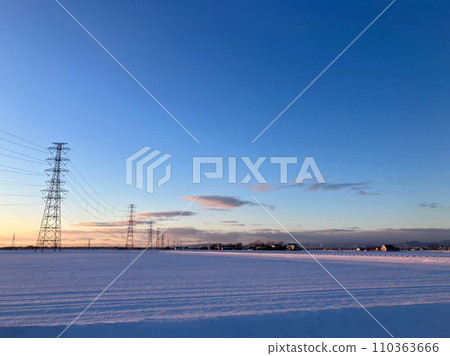 Towering steel tower amidst the snowy landscape and sunrise 110363666
