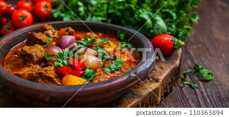 Traditional Georgian dish of tender veal stewed with onions and peppers - Chashushuli. Culinary pleasure while traveling to popular places in Georgia Traditional Georgian dish of tender veal stewed with onions and peppers - Chashushuli. Culinary pleasure while traveling to popular places in Georgia 110363894