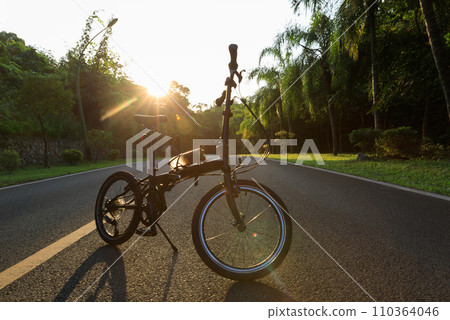 A folding bike on sunset road A folding bike on sunset road 110364046