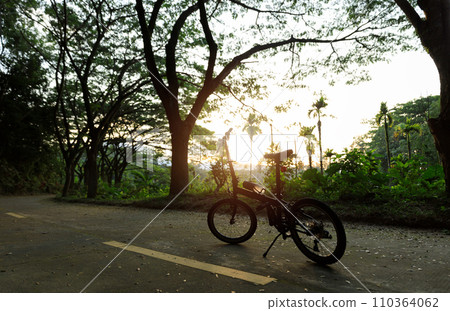 A folding bike on sunset road A folding bike on sunset road 110364062
