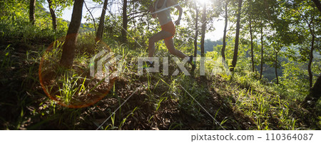 Trail runner running in summer forest trail 110364087