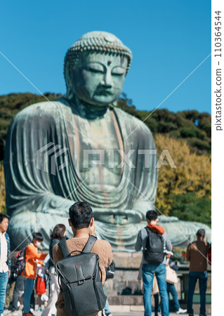 man tourist Visiting in Kamakura, Kanagawa, Japan. happy Traveler sightseeing the Great Buddha statue. Landmark and popular for tourists attraction near Tokyo. Travel and Vacation concept 110364544