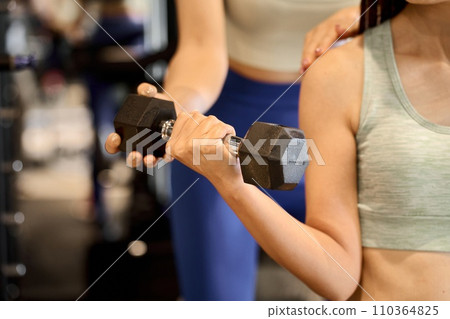 Woman training her arms with dumbbell arm curls Woman training her arms with dumbbell arm curls 110364825
