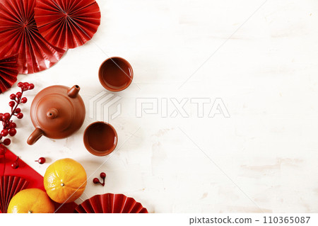 Chinese new year festival decorations with oranges, classic clay teapot and red Chinese folded fans. Chinese new year festival decorations with oranges, classic clay teapot and red Chinese folded fans. 110365087