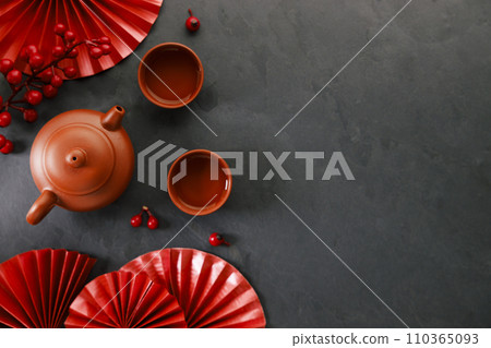 Chinese new year festival decorations with classic clay teapot and red Chinese folded fans. Chinese new year festival decorations with classic clay teapot and red Chinese folded fans. 110365093