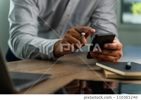 businessman holding a smartphone in the office, working online, looking mobile Communication and technology concepts 110365240