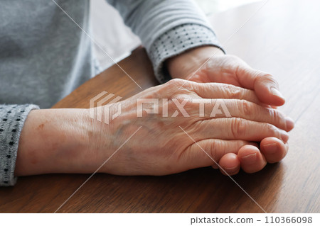 Elderly woman's hands stacked on the table 110366098