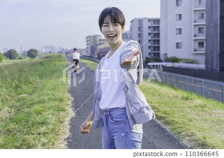 A young woman reaches out to him while running on the bank 110366645