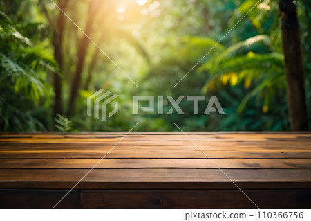 Empty wooden table top with blur jungle background with bokeh light. Empty wooden table top with blur jungle background with bokeh light. 110366756
