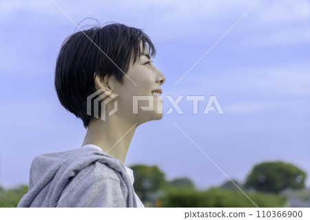 Young woman looking up at the blue sky on the bank Young woman looking up at the blue sky on the bank 110366900