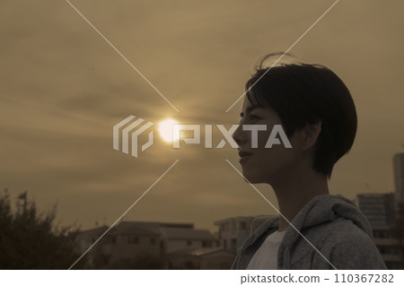 Young woman standing with sunset background Young woman standing with sunset background 110367282