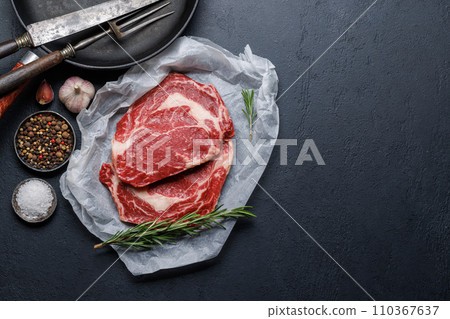 Raw ribeye steaks with savory spices 110367637