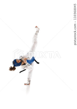 Athletic young girl in dobok and blue helmet practicing, training taekwondo isolated over white background Athletic young girl in dobok and blue helmet practicing, training taekwondo isolated over white background 110368045