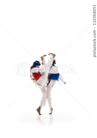 Dynamic image of young girls in helmet and dobok practicing taekwondo stunts, fighting isolated over white background Dynamic image of young girls in helmet and dobok practicing taekwondo stunts, fighting isolated over white background 110368051