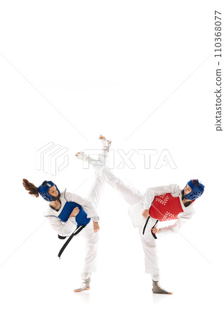 Full-length image of young competitive girls in dobok and helmet, practicing taekwondo, training isolated over white background Full-length image of young competitive girls in dobok and helmet, practicing taekwondo, training isolated over white background 110368077