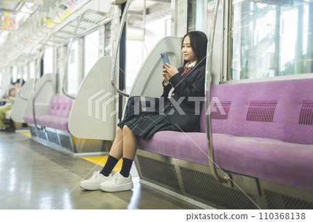 高中女孩在火車上看智慧型手機 高中女孩在火車上看智慧型手機 110368138