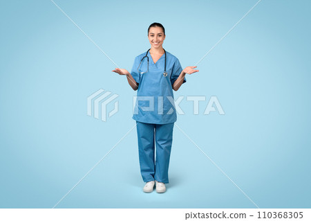 Happy woman nurse with open hands in blue scrubs 110368305