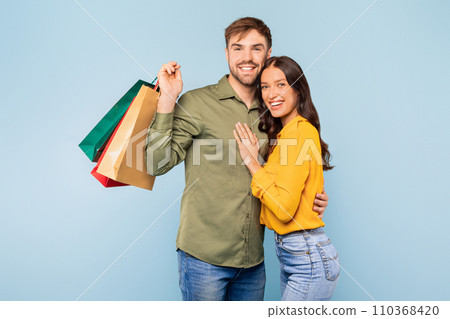 Happy couple with shopping bags on a blue background 110368420