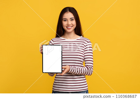 Pretty young asian woman showing digital tablet with white screen 110368687