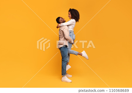 Black man lifting woman in joyful embrace, full length Black man lifting woman in joyful embrace, full length 110368689