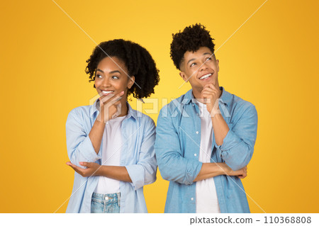 Smiling pensive young african american guy and woman in casual think, look at empty space Smiling pensive young african american guy and woman in casual think, look at empty space 110368808