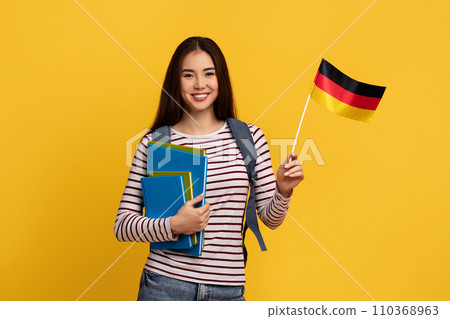 Happy young asian woman student showing flag of Germany 110368963