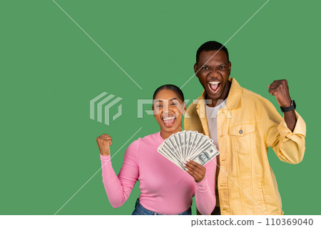 Emotional young african american couple with money cash clenching fists 110369040