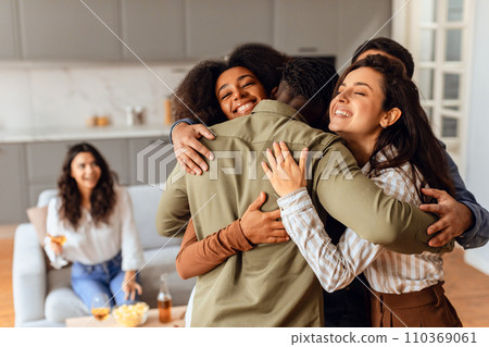 Group of diverse friends sharing hug during home party gathering 110369061