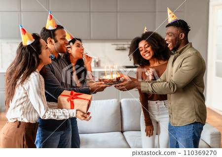 Diverse group of students celebrating birthday of friend at home 110369270