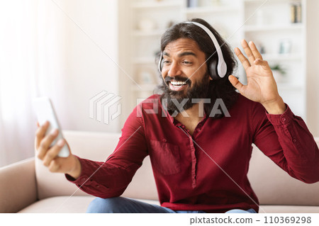 Portrait bearded young indian man have video call on phone 110369298
