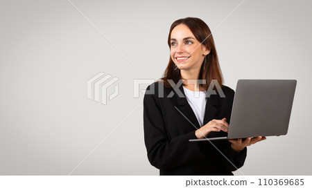 Happy young European woman in suit with laptop, computer, look at free space Happy young European woman in suit with laptop, computer, look at free space 110369685