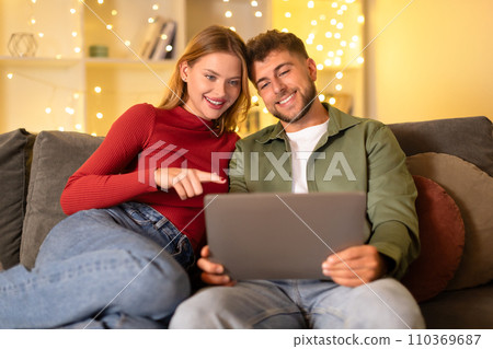 Couple enjoying time together with a laptop at home Couple enjoying time together with a laptop at home 110369687