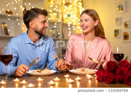 Joyful couple dining with wine and roses, enjoying conversation Joyful couple dining with wine and roses, enjoying conversation 110369709