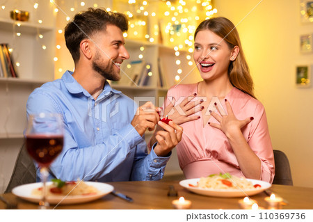 Woman elated by marriage proposal, man presents ring 110369736