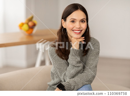 Portrait of cheerful brunette young woman posing at home Portrait of cheerful brunette young woman posing at home 110369738