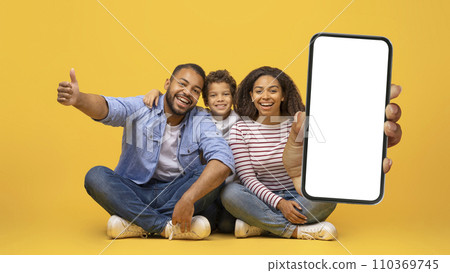 We Recommend. Smiling black family holding cell phone with white blank screen We Recommend. Smiling black family holding cell phone with white blank screen 110369745