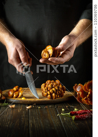 Flammulina velutipes and a knife in the hands of a chef before sorting and slicing on a kitchen cutting board. Delicious dietary lunch of fresh forest velvet shank or wild enoki Flammulina velutipes and a knife in the hands of a chef before sorting and slicing on a kitchen cutting board. Delicious dietary lunch of fresh forest velvet shank or wild enoki 110369786