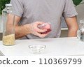 A man lays an egg and shakes a container of rice 110369799