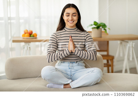A serene young woman in a striped turtleneck and light blue jeans 110369862