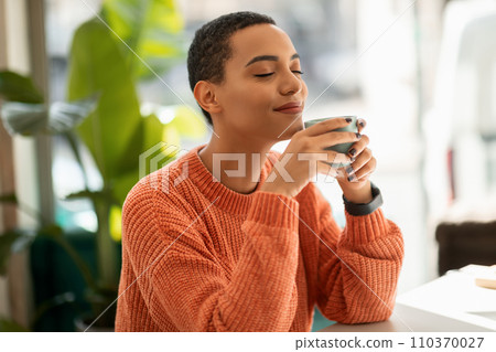 Glad calm pretty young latin woman enjoy peace and spare time, drink cup of coffee, warm moment 110370027