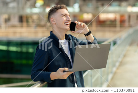 An enthusiastic young man in a blue jacket engaging in a phone conversation An enthusiastic young man in a blue jacket engaging in a phone conversation 110370091