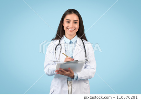 Female doctor writing on tablet with a smile 110370291